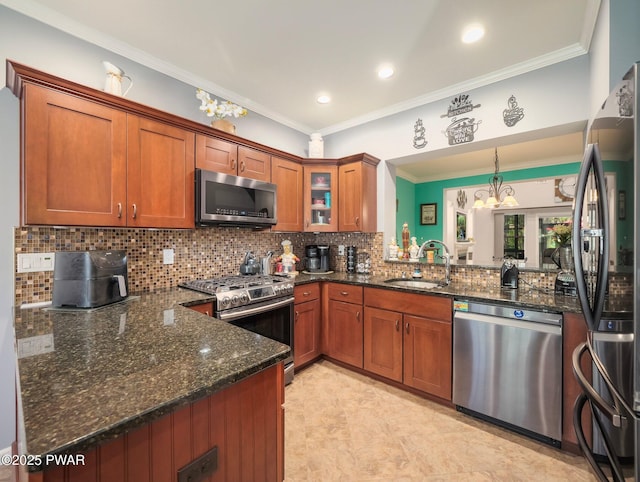 803 Macintosh Way, Matamoras, PA 18336 - kitchen with brown cabinetry, appliances with stainless steel finishes, a sink, an inviting chandelier, and dark stone counters