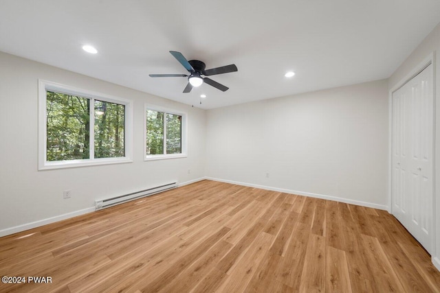 unfurnished bedroom with baseboard heating, ceiling fan, a closet, and light hardwood / wood-style flooring