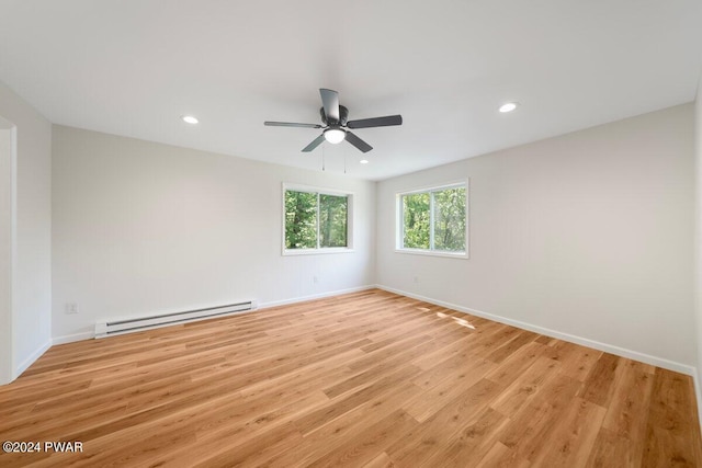 spare room featuring ceiling fan, light hardwood / wood-style floors, and a baseboard heating unit