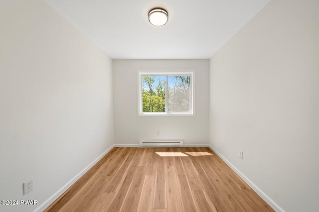 unfurnished room with light wood-type flooring and baseboard heating