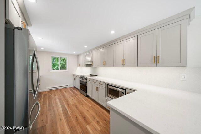 kitchen with appliances with stainless steel finishes, light hardwood / wood-style floors, custom exhaust hood, a baseboard radiator, and gray cabinets