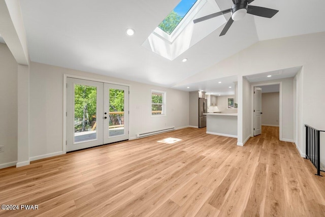 unfurnished living room with baseboard heating, vaulted ceiling with skylight, french doors, and light wood-type flooring