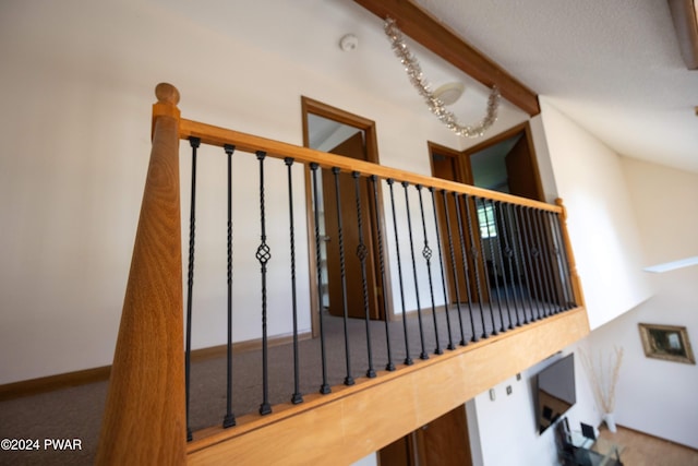 stairway featuring beamed ceiling