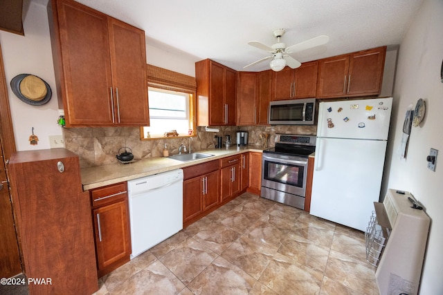 kitchen with backsplash, stainless steel appliances, ceiling fan, and sink