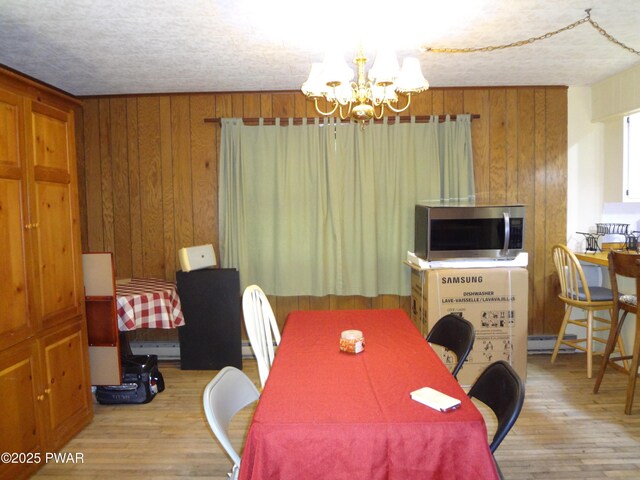115 Eastwood Dr, Greentown, PA 18426 - dining space with a chandelier, wood finished floors, and wooden walls