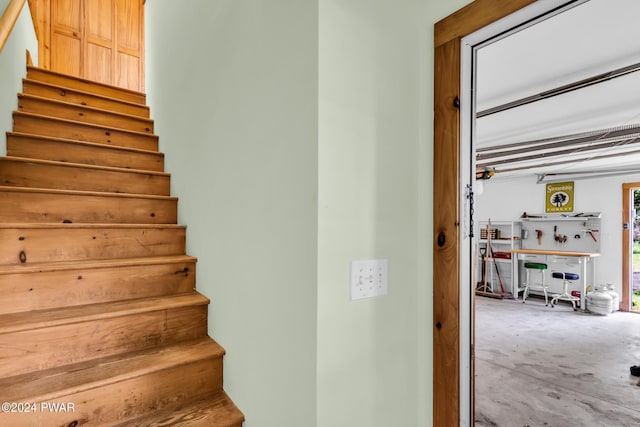 staircase featuring a workshop area and concrete floors