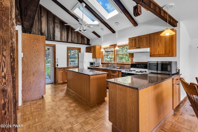 kitchen featuring beam ceiling, a skylight, pendant lighting, white appliances, and a kitchen island