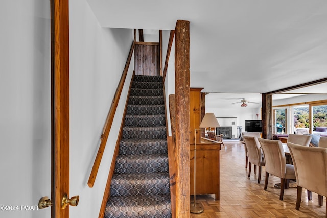 stairway featuring ceiling fan and parquet floors