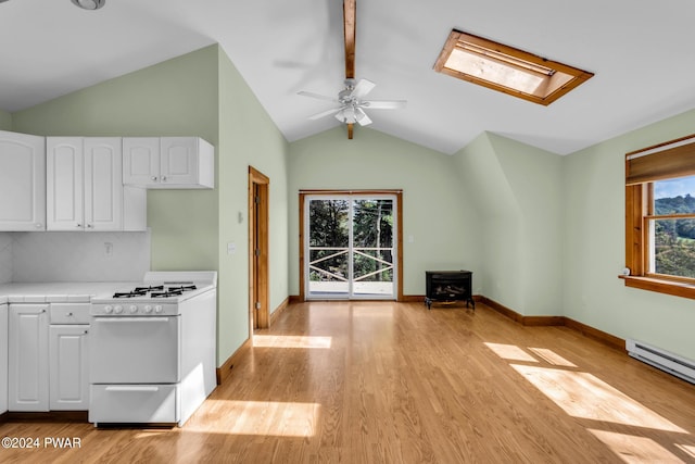 kitchen with decorative backsplash, light wood-type flooring, white range oven, lofted ceiling with skylight, and white cabinets