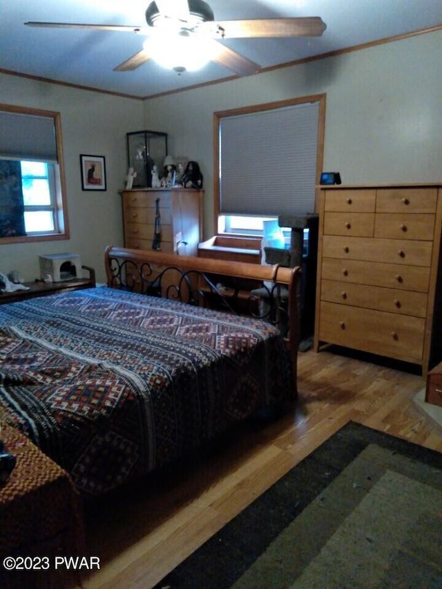 bedroom with ceiling fan, crown molding, and hardwood / wood-style flooring