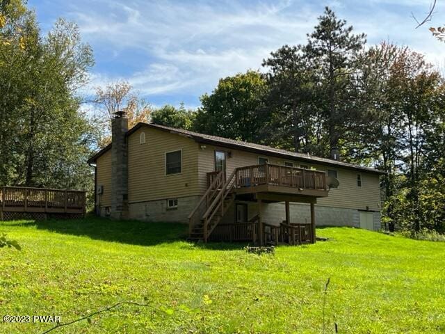 back of house featuring a yard and a deck