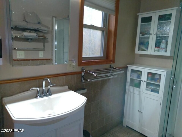 bathroom featuring vanity and tile walls