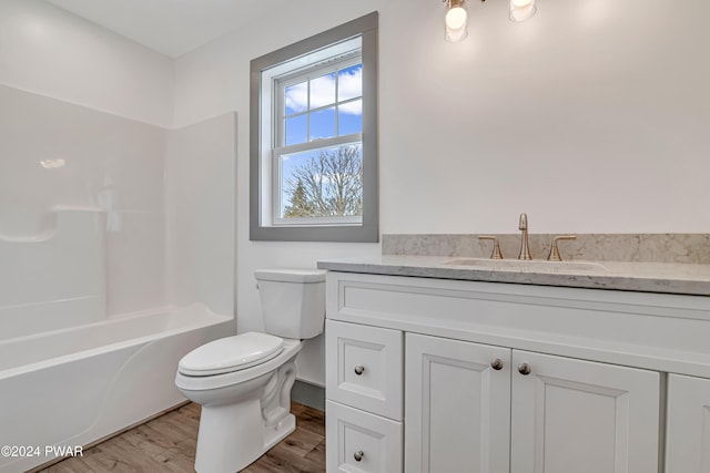 full bathroom with vanity, toilet, wood-type flooring, and washtub / shower combination