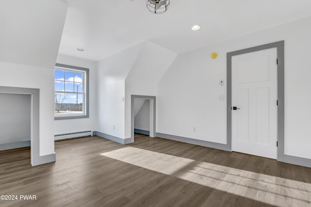 additional living space with light hardwood / wood-style floors, lofted ceiling, and a baseboard heating unit