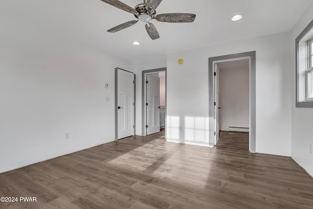 unfurnished bedroom with hardwood / wood-style floors, ceiling fan, and a baseboard radiator