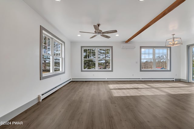 empty room featuring a wall mounted air conditioner, hardwood / wood-style floors, a baseboard heating unit, and a healthy amount of sunlight