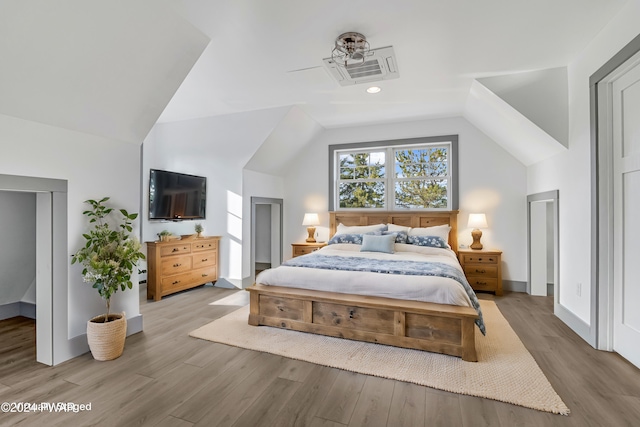 bedroom with light wood-type flooring and vaulted ceiling