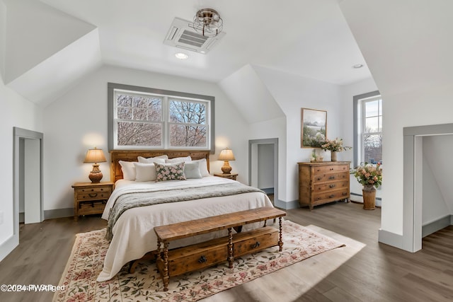 bedroom with hardwood / wood-style flooring, lofted ceiling, and multiple windows