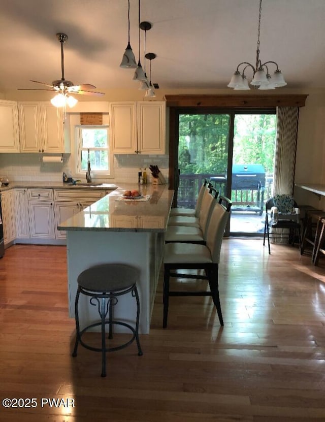127 E Mulberry Dr, Milford, PA 18337 - kitchen with white cabinetry, a kitchen breakfast bar, pendant lighting, and light wood-style floors