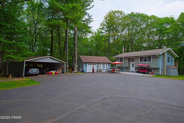 127 E Mulberry Dr, Milford, PA 18337 - view of front of home with a detached carport, a garage, view of scattered trees, and a storage shed
