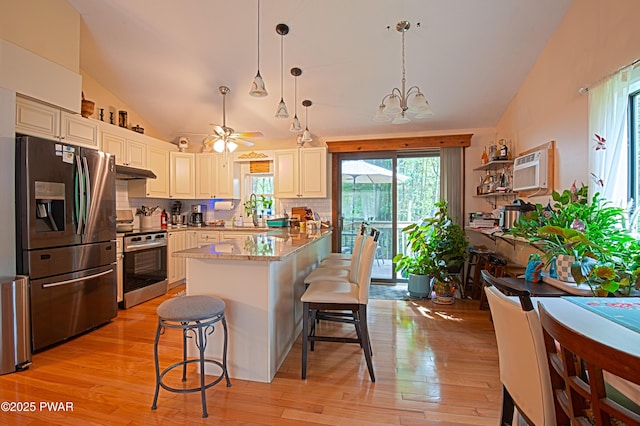 127 E Mulberry Dr, Milford, PA 18337 - kitchen with appliances with stainless steel finishes, a kitchen bar, vaulted ceiling, healthy amount of natural light, and light wood-style floors