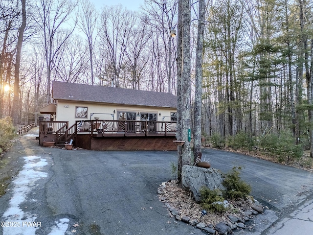 24 Lakeside Dr, Lakeville, PA 18438 - view of front of house featuring a deck, stucco siding, and driveway
