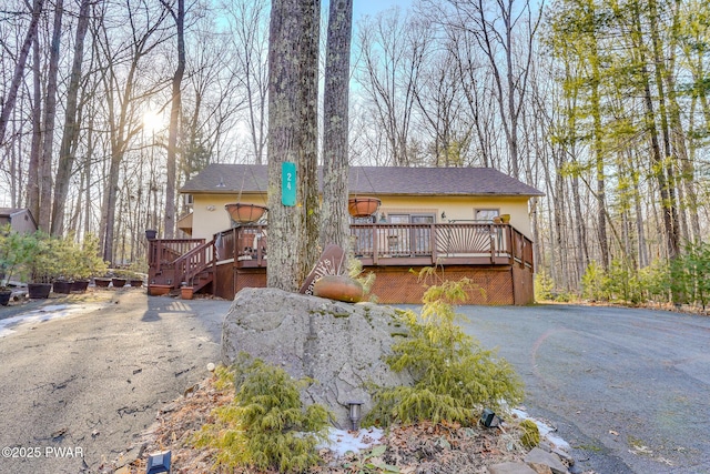 24 Lakeside Dr, Lakeville, PA 18438 - rustic home with a wooden deck, stucco siding, and stairs