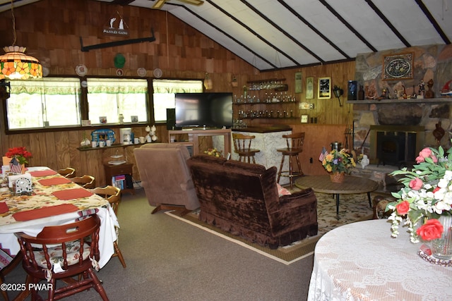 121 Mountain View Dr, Lords Valley, PA 18428 - carpeted living area with lofted ceiling, wood walls, and a stone fireplace