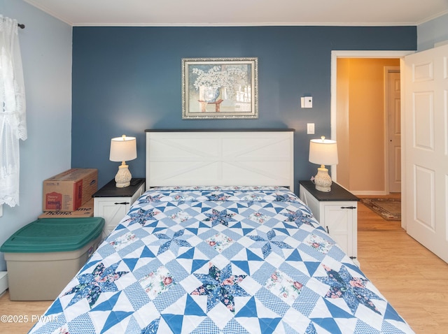 bedroom featuring crown molding and light hardwood / wood-style flooring