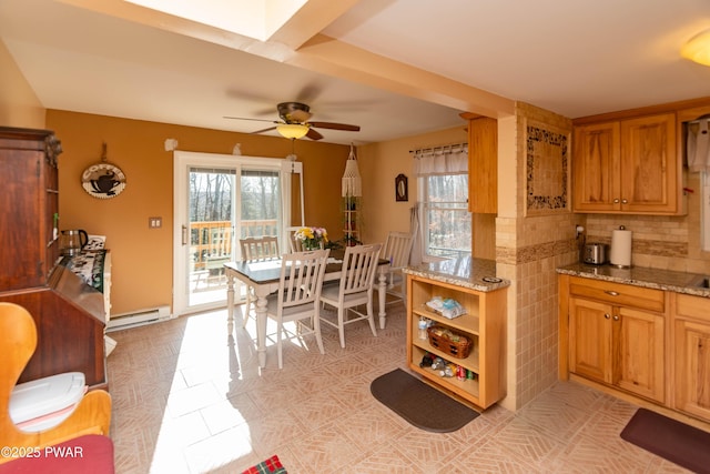 kitchen featuring light stone counters, light tile patterned floors, ceiling fan, and baseboard heating