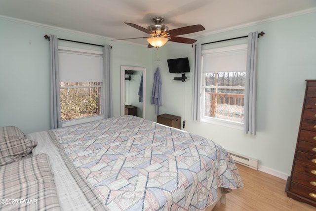 bedroom with ornamental molding, ceiling fan, baseboard heating, and light hardwood / wood-style flooring