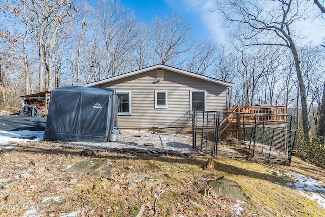 rear view of property featuring a wooden deck