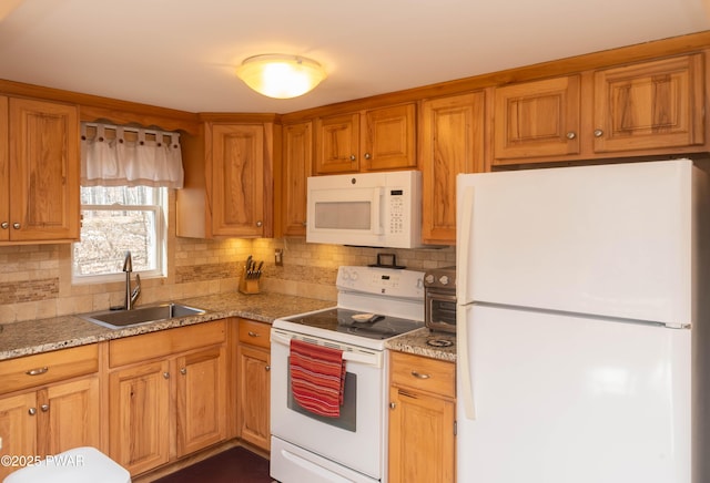 kitchen with light stone counters, sink, white appliances, and backsplash