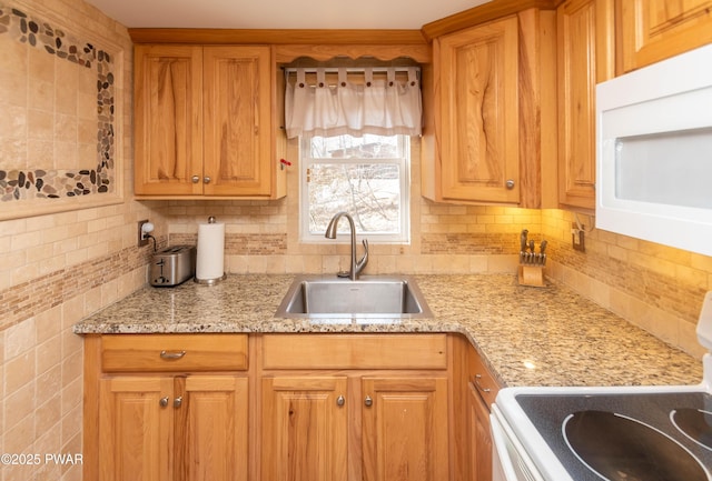 kitchen with light stone counters, white appliances, sink, and decorative backsplash