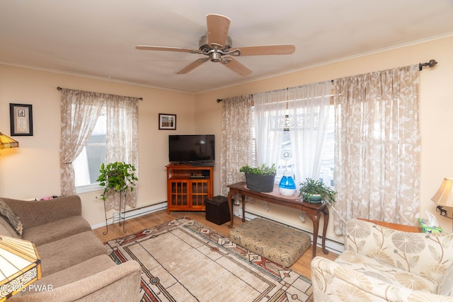 living room featuring wood-type flooring, a baseboard heating unit, ceiling fan, and ornamental molding