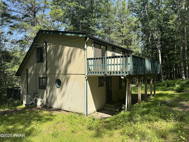 219 Woodpecker Ct, Bushkill, PA 18324 - view of property exterior featuring a deck and a lawn