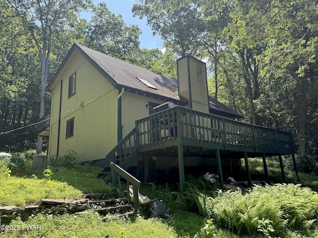 219 Woodpecker Ct, Bushkill, PA 18324 - back of house featuring a deck, a chimney, stairs, and a shingled roof