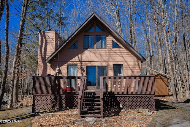 back of property featuring a chimney and a deck