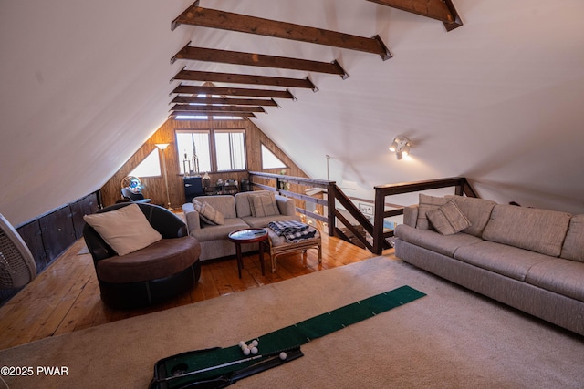 living area featuring hardwood / wood-style floors, lofted ceiling with beams, and wood walls