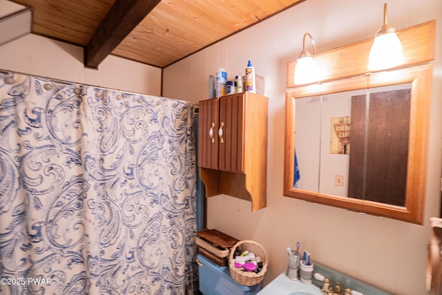 bathroom with beamed ceiling, a shower with curtain, wood ceiling, and wooden walls