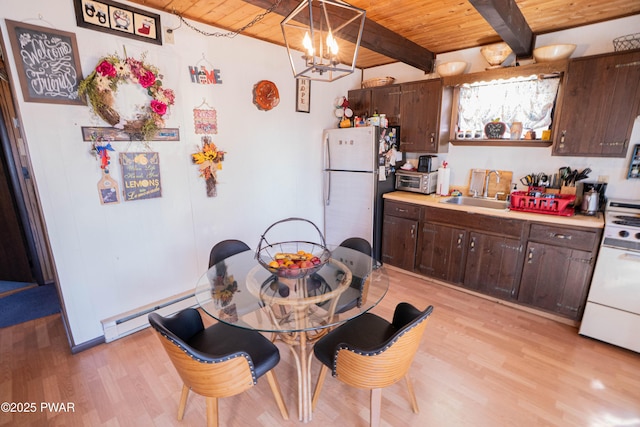 kitchen featuring wooden ceiling, range, freestanding refrigerator, and a sink