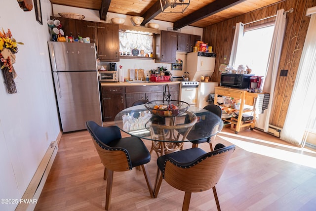 kitchen with a baseboard radiator, freestanding refrigerator, a sink, black microwave, and wooden ceiling