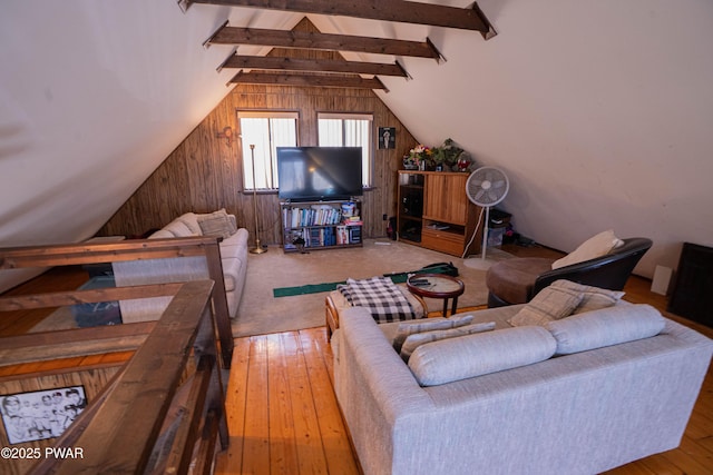 living area with wooden walls, vaulted ceiling with beams, and hardwood / wood-style flooring