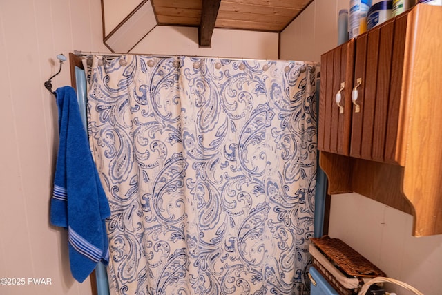 full bathroom featuring a shower with curtain, wooden ceiling, and wooden walls