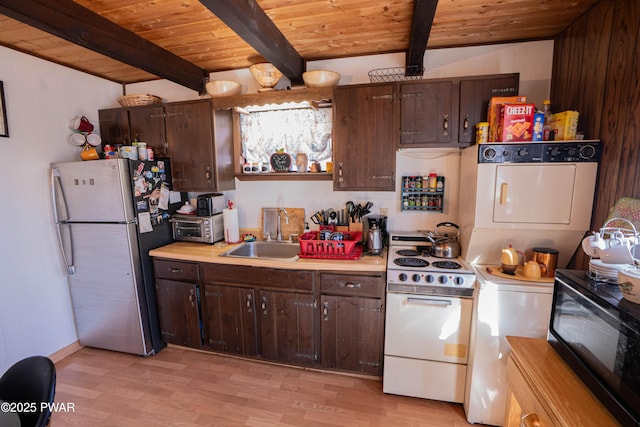 kitchen with freestanding refrigerator, a sink, light countertops, black microwave, and white range with electric stovetop