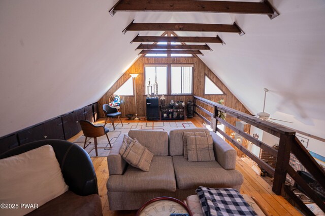 living area featuring hardwood / wood-style floors, lofted ceiling with beams, and wood walls