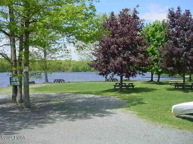 view of home's community featuring a lawn and a water view