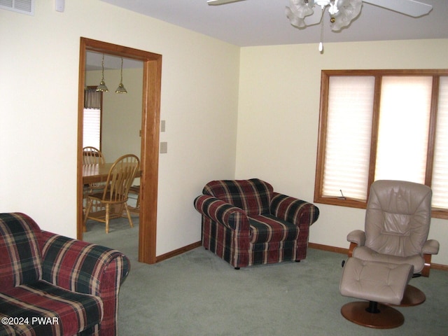 living area with carpet flooring and ceiling fan