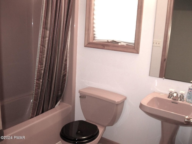 full bathroom featuring sink, shower / tub combo, and toilet