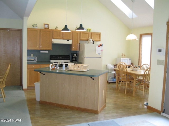 kitchen with white appliances, a kitchen island with sink, sink, a skylight, and decorative light fixtures